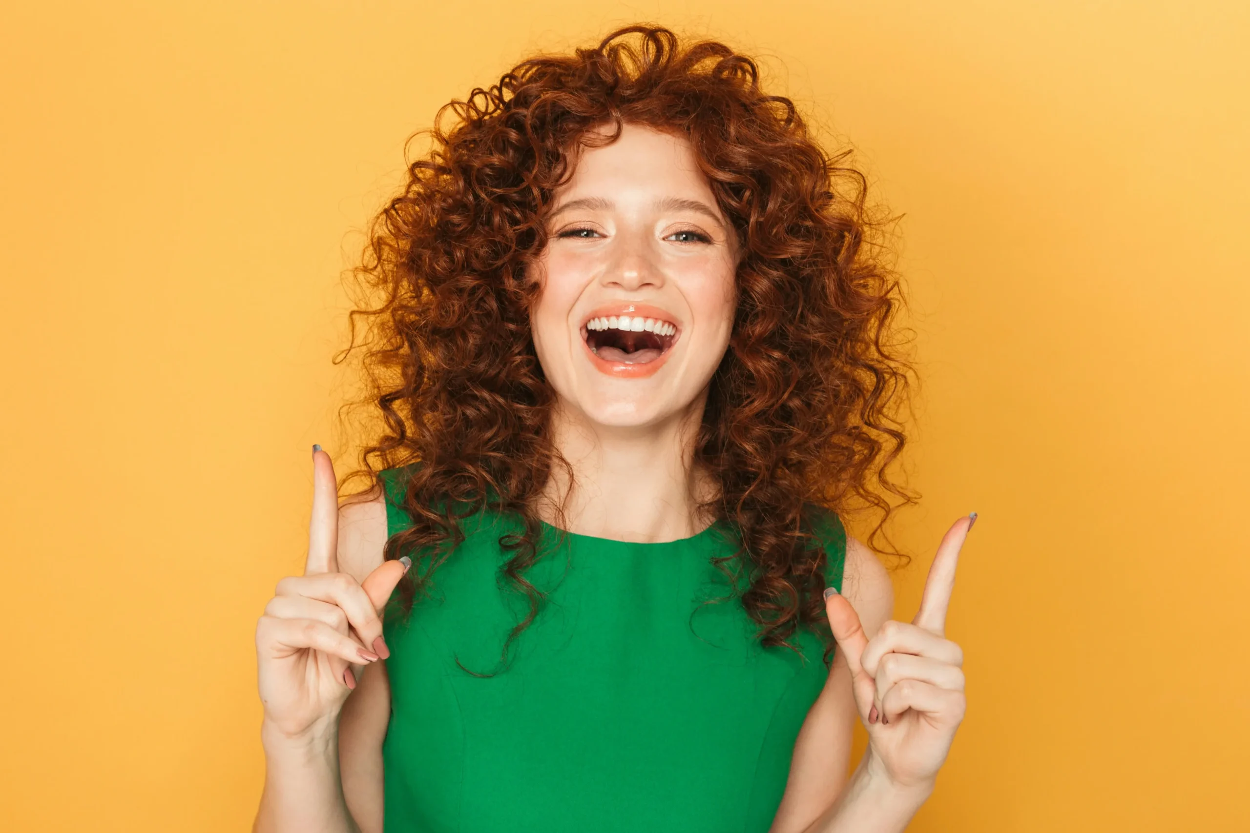 Jeune fille rousse bouclée heureuse et souriante
