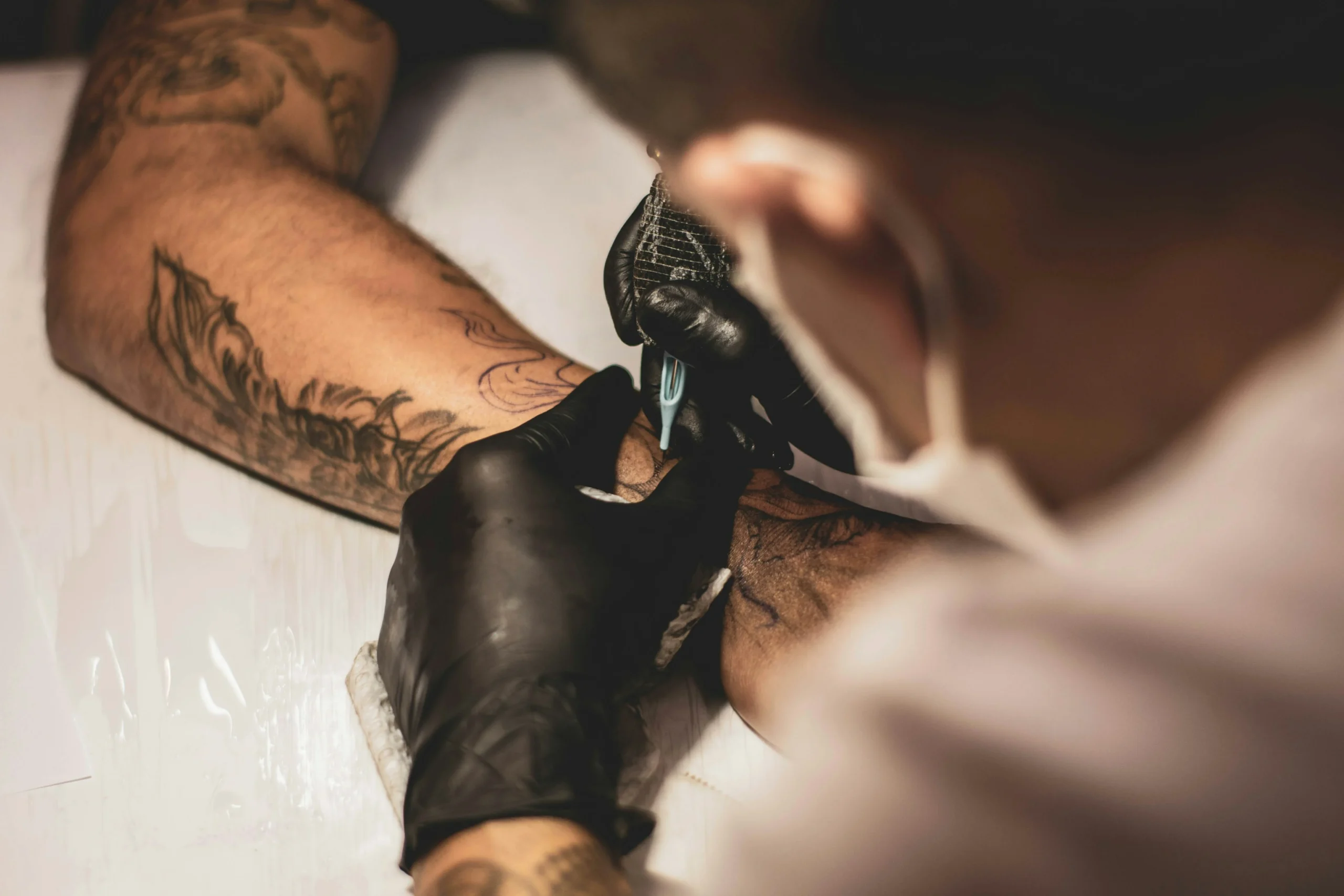Tatoeëerder tatoeëert de voorkant van een arm