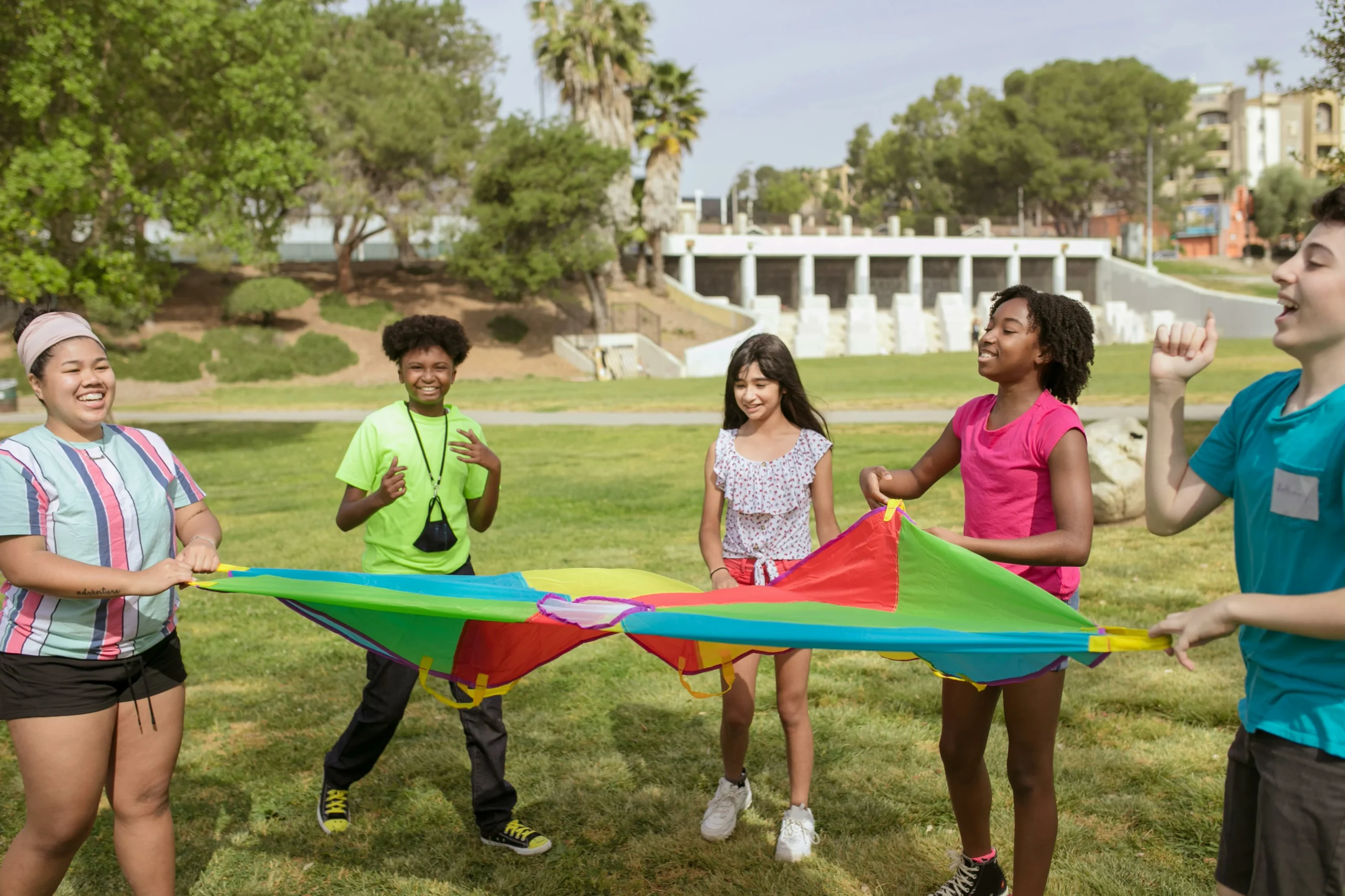 enfants qui jouent dehors avec un draps coloré